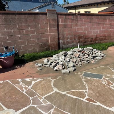 Pile of broken concrete on a backyard patio in Downey before removal