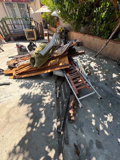 Backyard pile of old windows, doors, lumber and scrap metal before removal